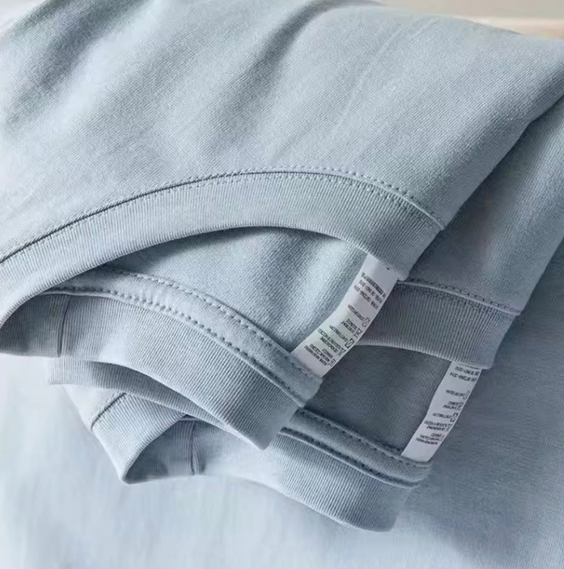 Folded cotton t-shirts showing stitched hem and sleeve detail
